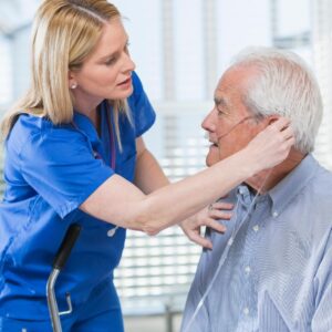 Nurse helping her elderly patient with his oxygen concentrator